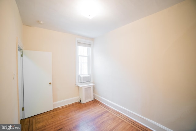 spare room featuring radiator, light hardwood / wood-style flooring, and cooling unit