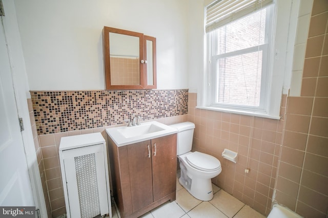 bathroom with tile patterned floors, plenty of natural light, tile walls, and vanity