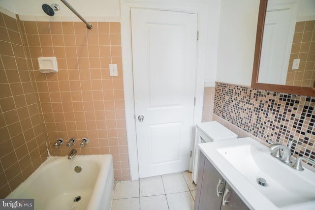 bathroom featuring backsplash, tile patterned floors, vanity, tiled shower / bath combo, and tile walls