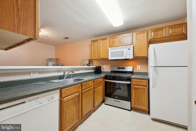 kitchen featuring sink, white appliances, and kitchen peninsula