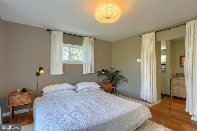 bedroom featuring baseboards and wood finished floors