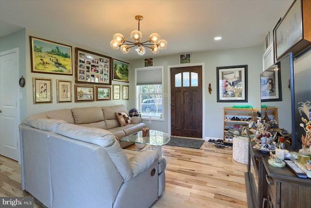 living area featuring light wood-style floors, baseboards, a notable chandelier, and recessed lighting