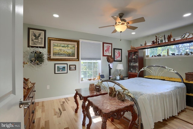 bedroom featuring light wood-type flooring, multiple windows, baseboards, and recessed lighting