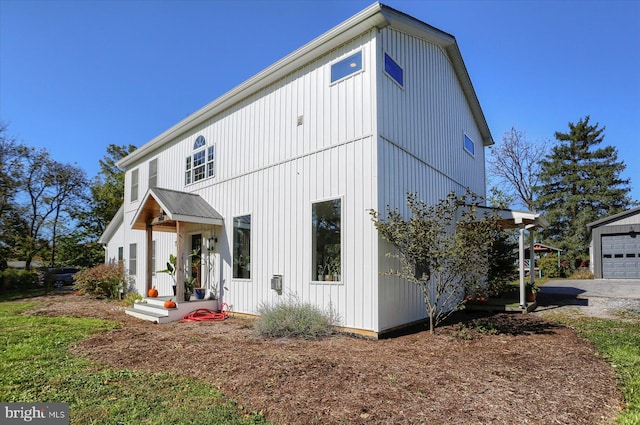 view of front facade with board and batten siding and an outbuilding