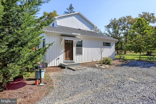 rear view of property with a shingled roof