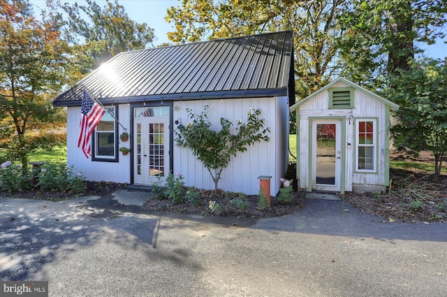 view of front of house featuring metal roof and an outbuilding