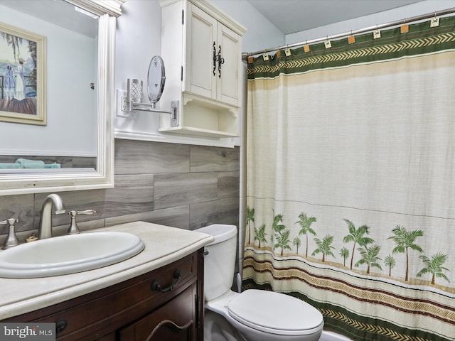 bathroom with vanity, toilet, and tile walls