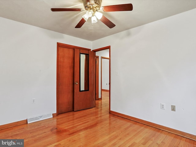 unfurnished bedroom with a closet, visible vents, light wood-style flooring, a ceiling fan, and baseboards