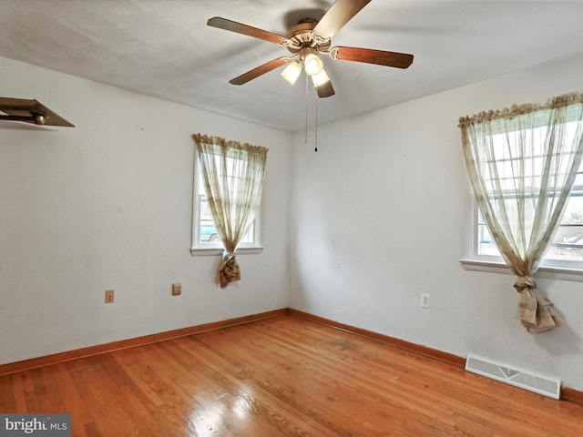 spare room with light wood-style flooring, visible vents, ceiling fan, and baseboards