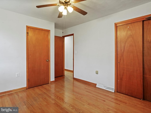 unfurnished bedroom with ceiling fan, light wood-style flooring, visible vents, and baseboards