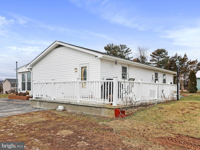 back of house with a lawn and a wooden deck