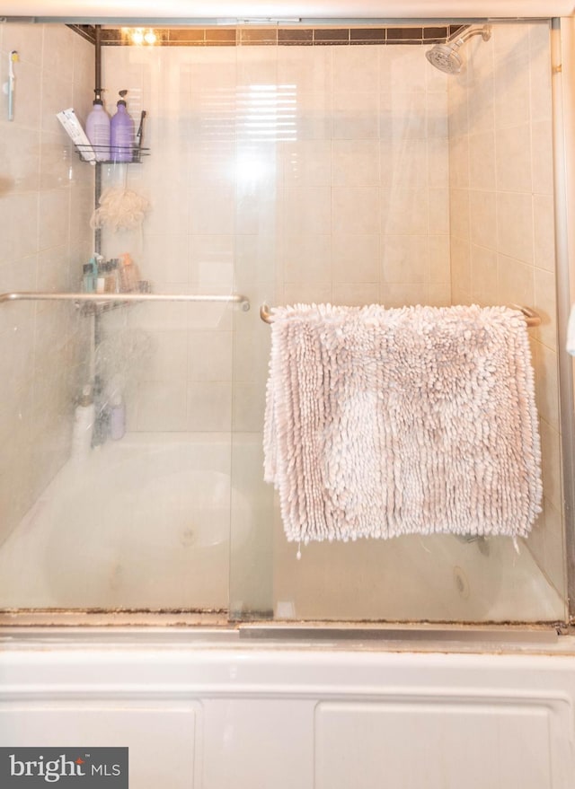 bathroom with bath / shower combo with glass door