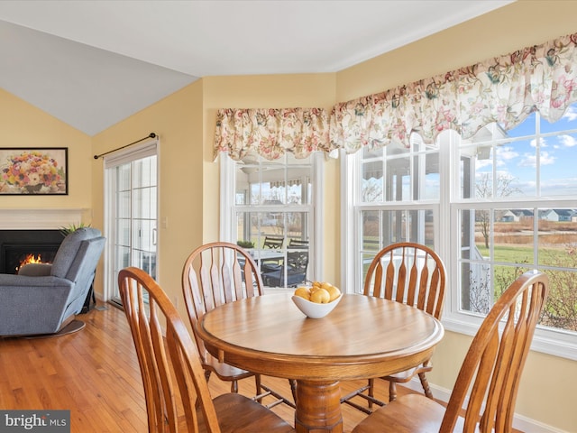 dining room with vaulted ceiling and light hardwood / wood-style floors