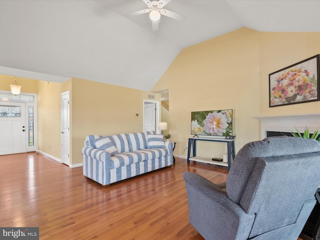 living room featuring vaulted ceiling, ceiling fan, and hardwood / wood-style floors