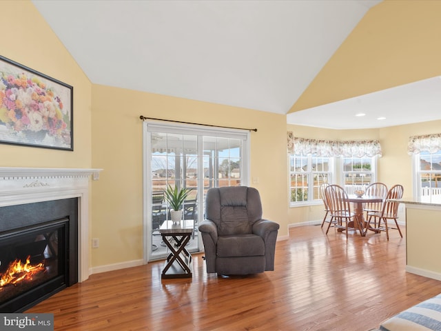 sitting room featuring lofted ceiling, a healthy amount of sunlight, and light wood-type flooring