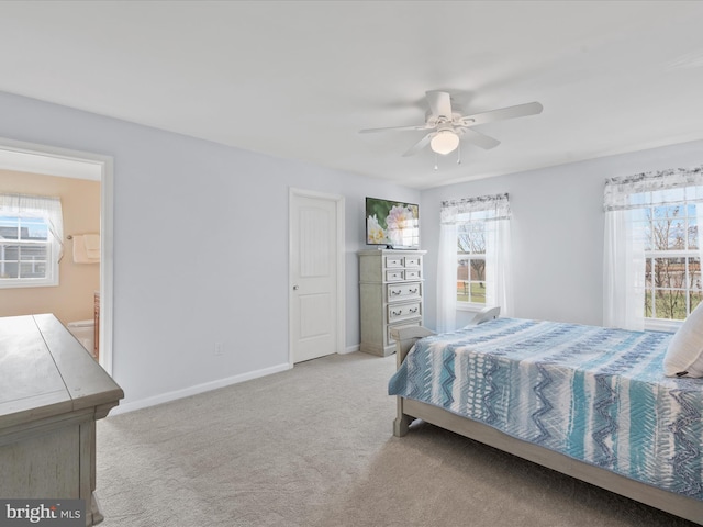 carpeted bedroom with ceiling fan and ensuite bath