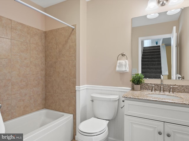 full bathroom featuring tiled shower / bath, vanity, and toilet