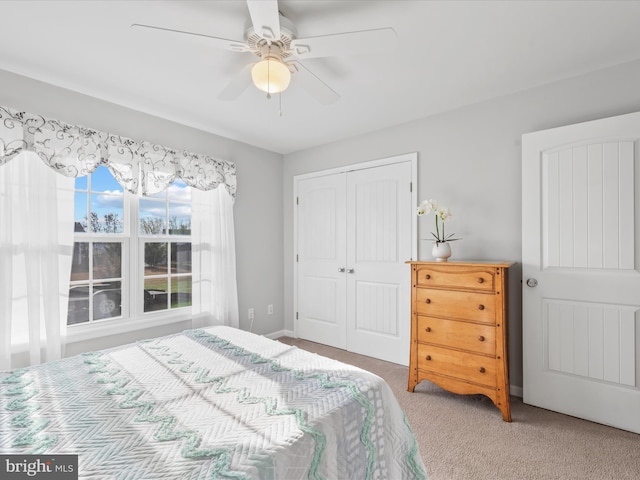 carpeted bedroom with ceiling fan and a closet