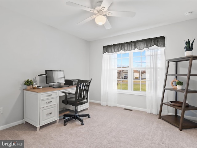 carpeted office with a wealth of natural light and ceiling fan