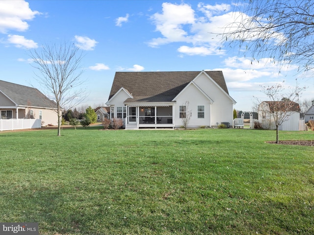 back of property with a yard and a sunroom