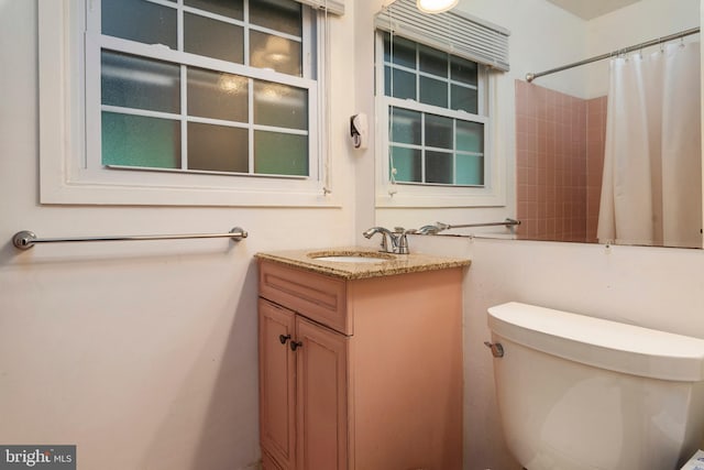 bathroom featuring curtained shower, vanity, and toilet