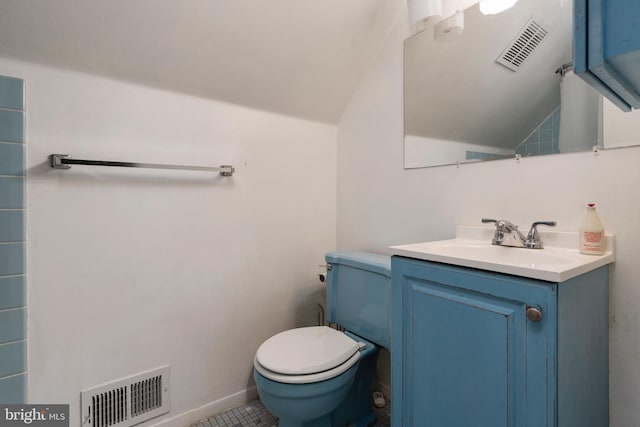 bathroom featuring tile patterned flooring, vanity, vaulted ceiling, and toilet