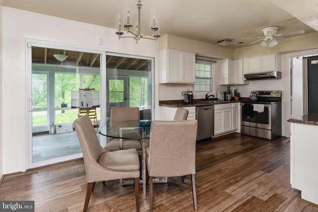 dining room featuring sink, dark wood-type flooring, and ceiling fan with notable chandelier