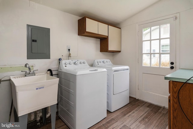 laundry room featuring cabinets, sink, light hardwood / wood-style flooring, washing machine and clothes dryer, and electric panel