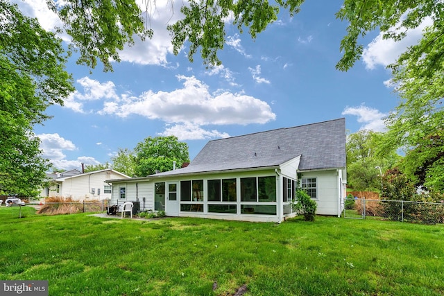 back of house with a lawn and a sunroom