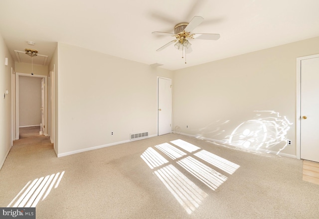 spare room with light colored carpet and ceiling fan