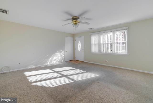 carpeted spare room featuring ceiling fan