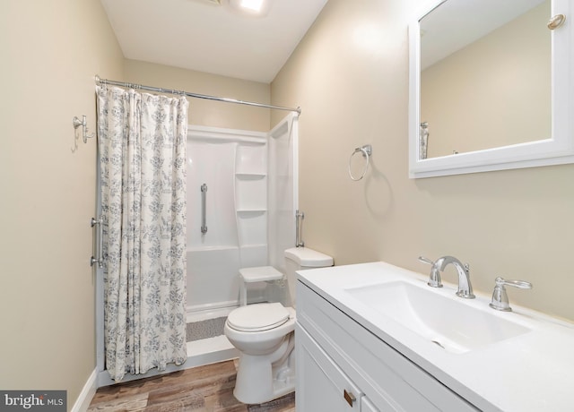 bathroom featuring walk in shower, toilet, vanity, and hardwood / wood-style flooring