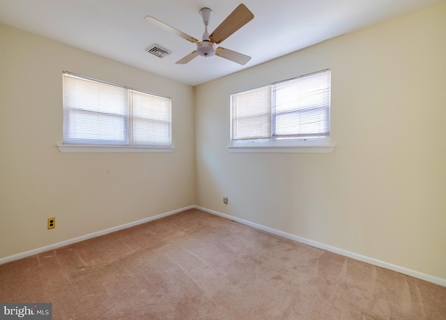 carpeted spare room featuring ceiling fan