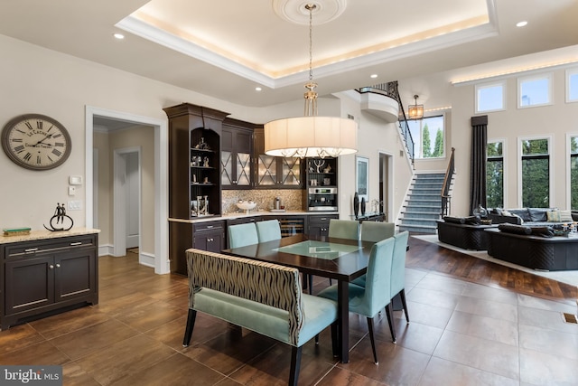 dining room with a tray ceiling and dark tile patterned flooring