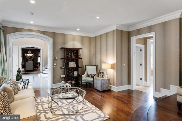 living room with dark hardwood / wood-style flooring, crown molding, and a chandelier