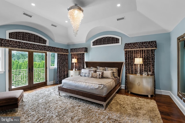 bedroom featuring french doors, hardwood / wood-style floors, a chandelier, a tray ceiling, and access to outside