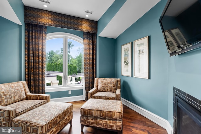 sitting room featuring hardwood / wood-style flooring, a wealth of natural light, lofted ceiling, and a tiled fireplace