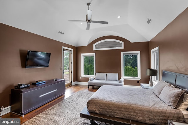 bedroom featuring ceiling fan, dark hardwood / wood-style flooring, access to exterior, and lofted ceiling