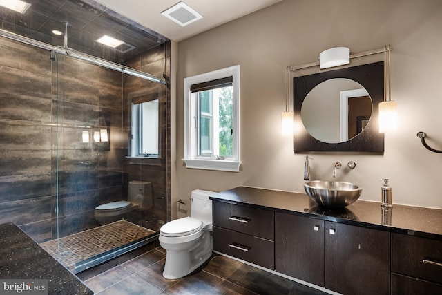 bathroom featuring a shower with door, vanity, and toilet