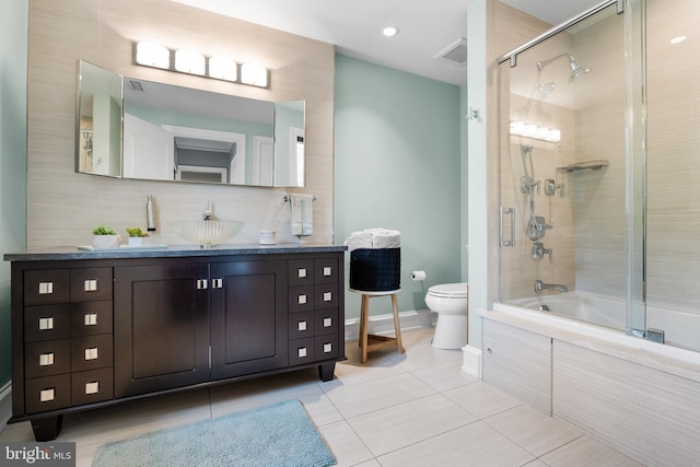 full bathroom with tile patterned floors, toilet, combined bath / shower with glass door, and backsplash