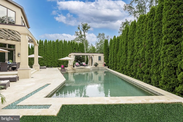 view of swimming pool with an outbuilding and a patio