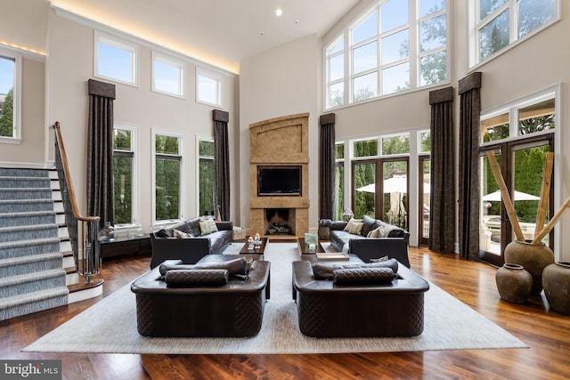 living room featuring hardwood / wood-style flooring and a towering ceiling