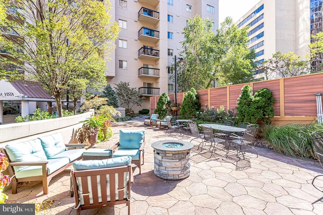 view of patio with an outdoor living space with a fire pit