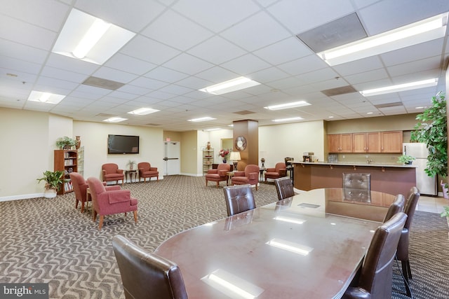 dining area featuring a paneled ceiling and carpet