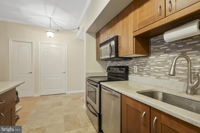 kitchen with sink, hanging light fixtures, ornamental molding, appliances with stainless steel finishes, and tasteful backsplash