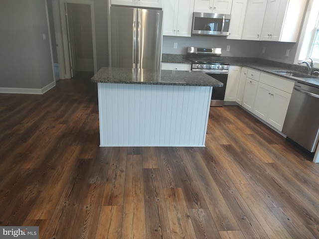 kitchen featuring white cabinetry, sink, a kitchen island, and appliances with stainless steel finishes