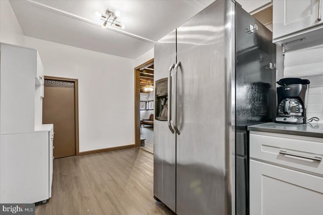 kitchen with stainless steel fridge with ice dispenser, light hardwood / wood-style flooring, and white cabinetry