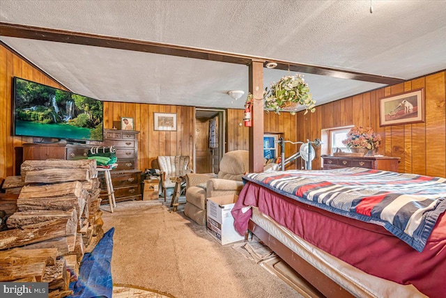 bedroom featuring lofted ceiling, wooden walls, carpet floors, and a textured ceiling