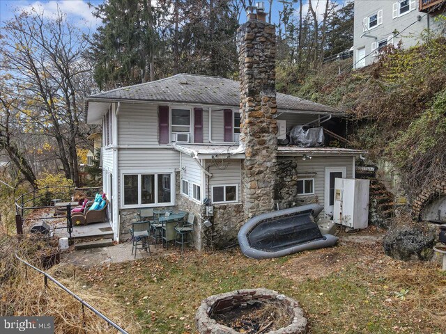 5449 Depues Rd, Bangor, PA 18013 - back of house featuring a fire pit, stone siding, a chimney, a patio, and cooling unit