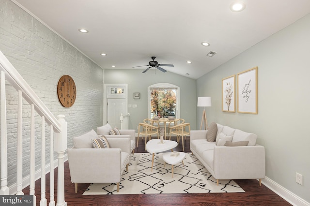 living room featuring ceiling fan, wood-type flooring, brick wall, and lofted ceiling